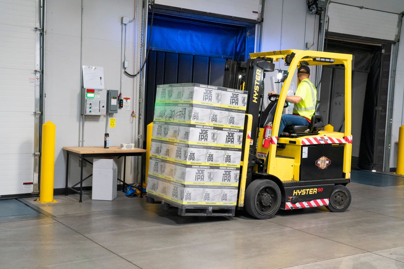 Forklift operator moving goods inside a commercial warehouse